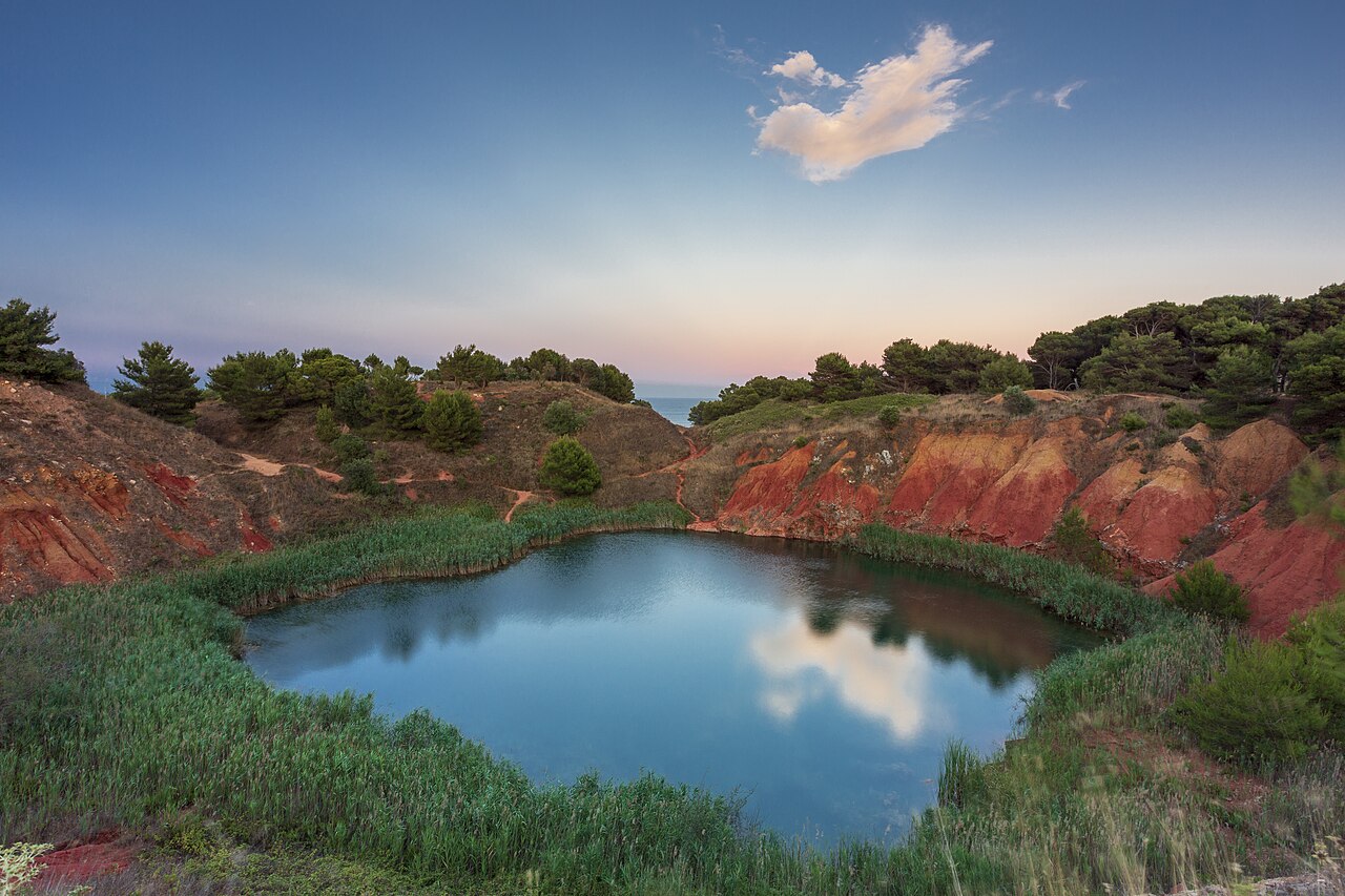 The emerald pond and red earth of the Otranto bauxite quarry